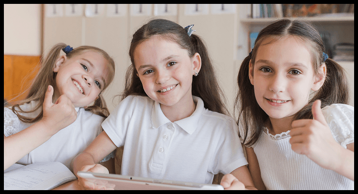 Three students smiling in classroom
